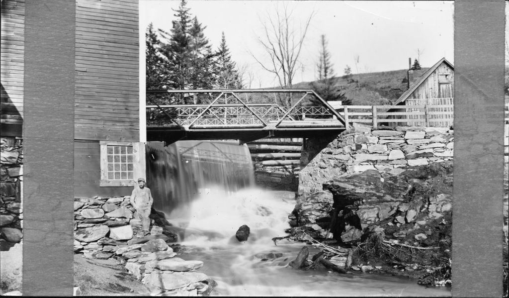 Miniature of Man leaning against a building next to a stream and dam