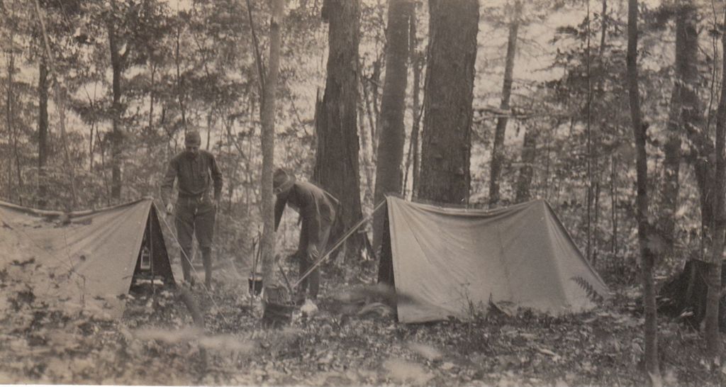 Miniature of Men setting up tents and campsite