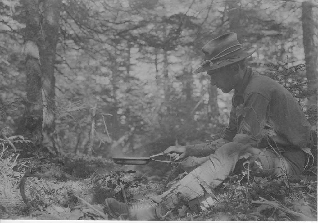 Miniature of Man cooking over camp fire