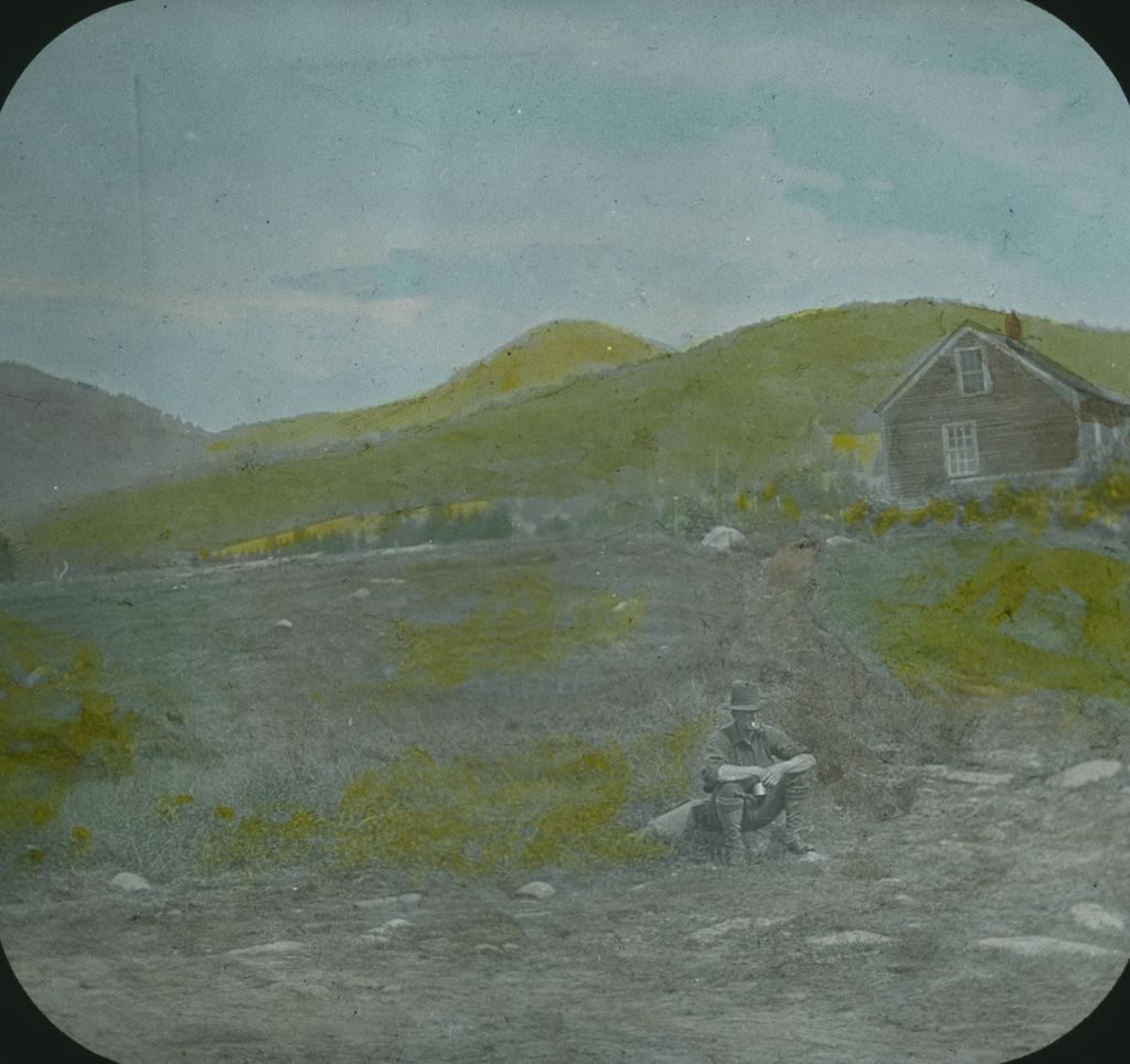 Miniature of Man sitting in front of a cabin