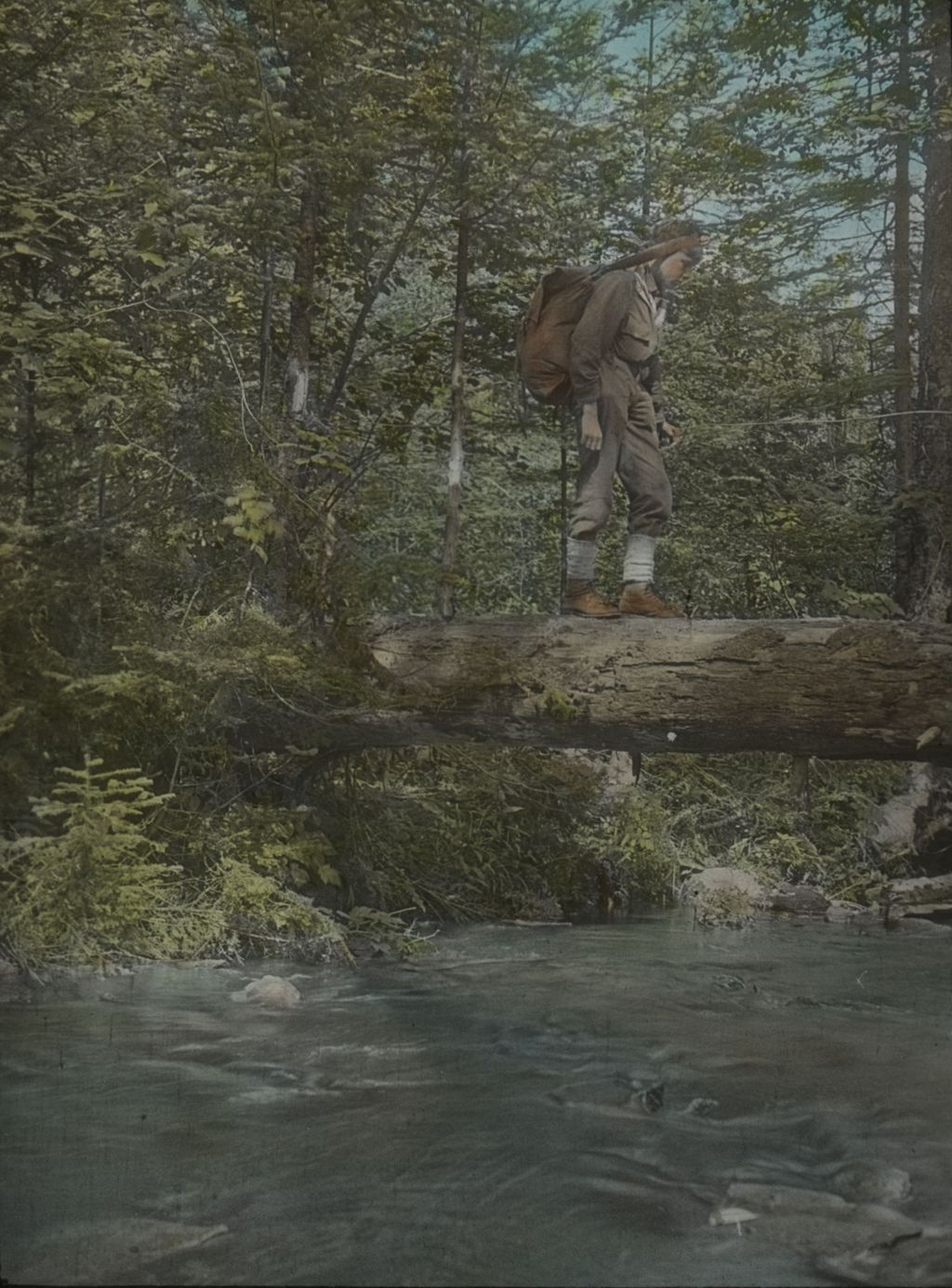 Miniature of Leverett Smith crossing a log bridge at the outlet of Buffum Pond